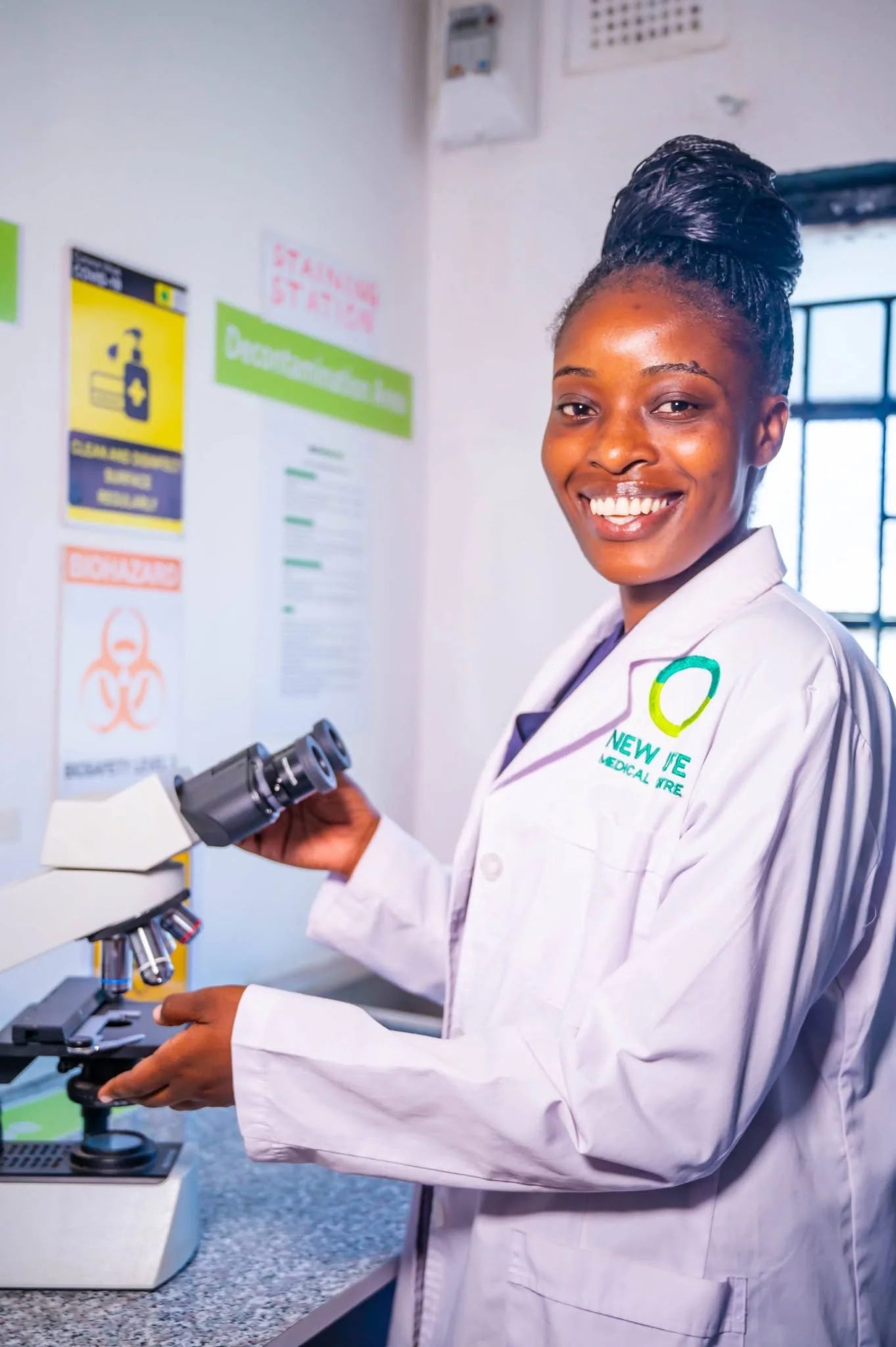 New Life Medical Centre laboratory professional using a microscope